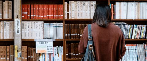 Woman browsing books at a library in Nagano, Japan. Explore knowledge and literature.